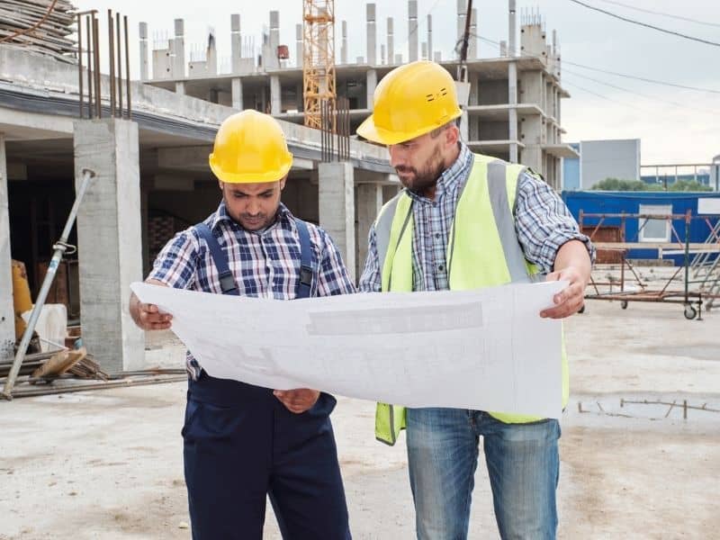 Commercial construction team reviewing site plans for zoning compliance and ALTA survey data review